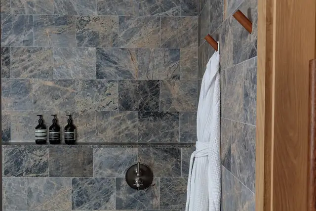 Austin Proper Hotel en Austin, baño con pared de mármol y toallero