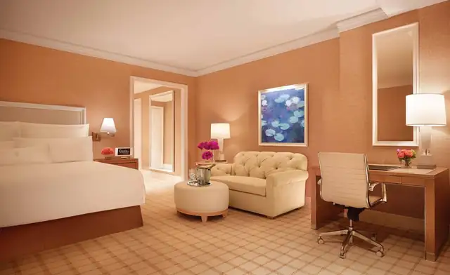 Encore Boston Harbor en Everett, habitación con cama grande y sillón con otomana