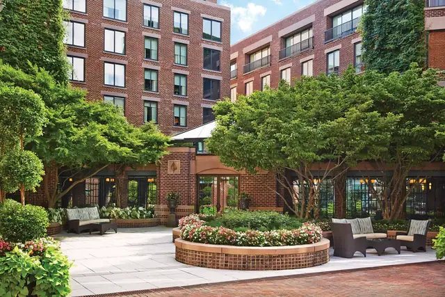 Four Seasons Washington DC en Georgetown, patio de ladrillo con mesas y vegetación