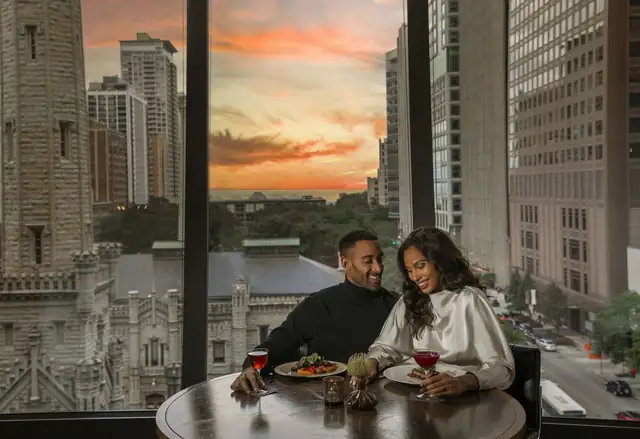 Park Hyatt Chicago en Chicago, pareja cenando con vista a la ciudad al atardecer