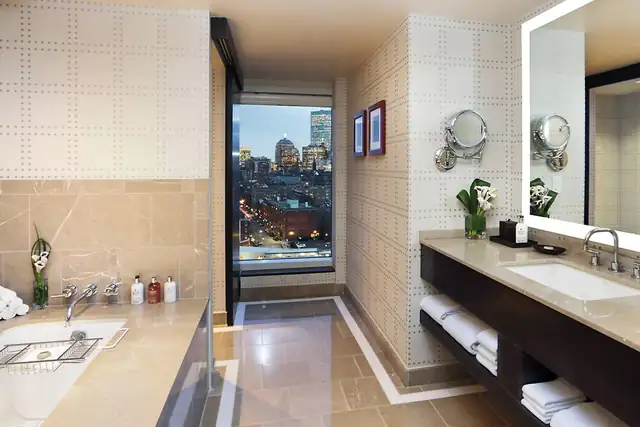 The Liberty en Boston, baño moderno con doble lavabo y espejo grande