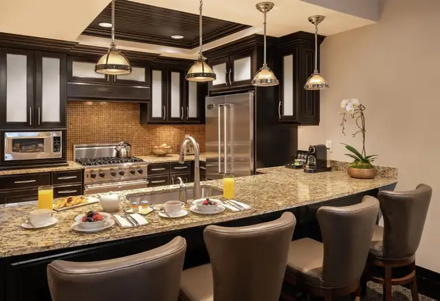 Waldorf Astoria Park City, cocina moderna con muebles oscuros y electrodomésticos de acero